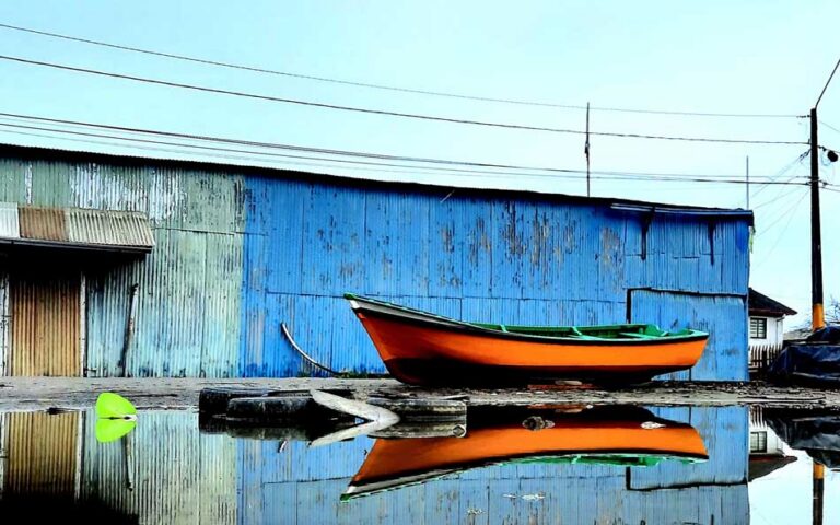 barco encallado frente a una construcción de lata